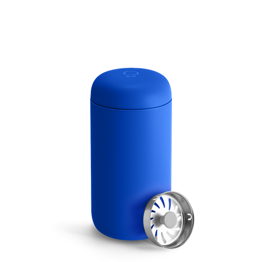An Electric Cobalt Fellow Carter Move Mug sits next to a cylindrical metal infuser.