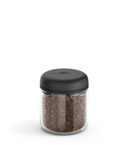 Fellow Atmos Vacuum Canister with black lid, storing coffee beans on a white background.